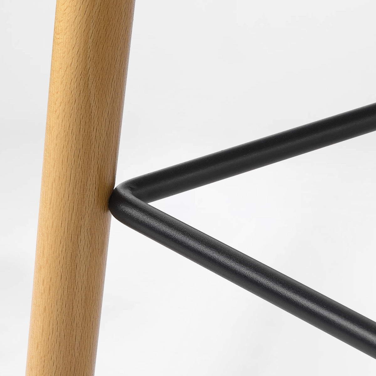 Eureka Ergonomic Perchamp black footrest bar attached to an oak leg