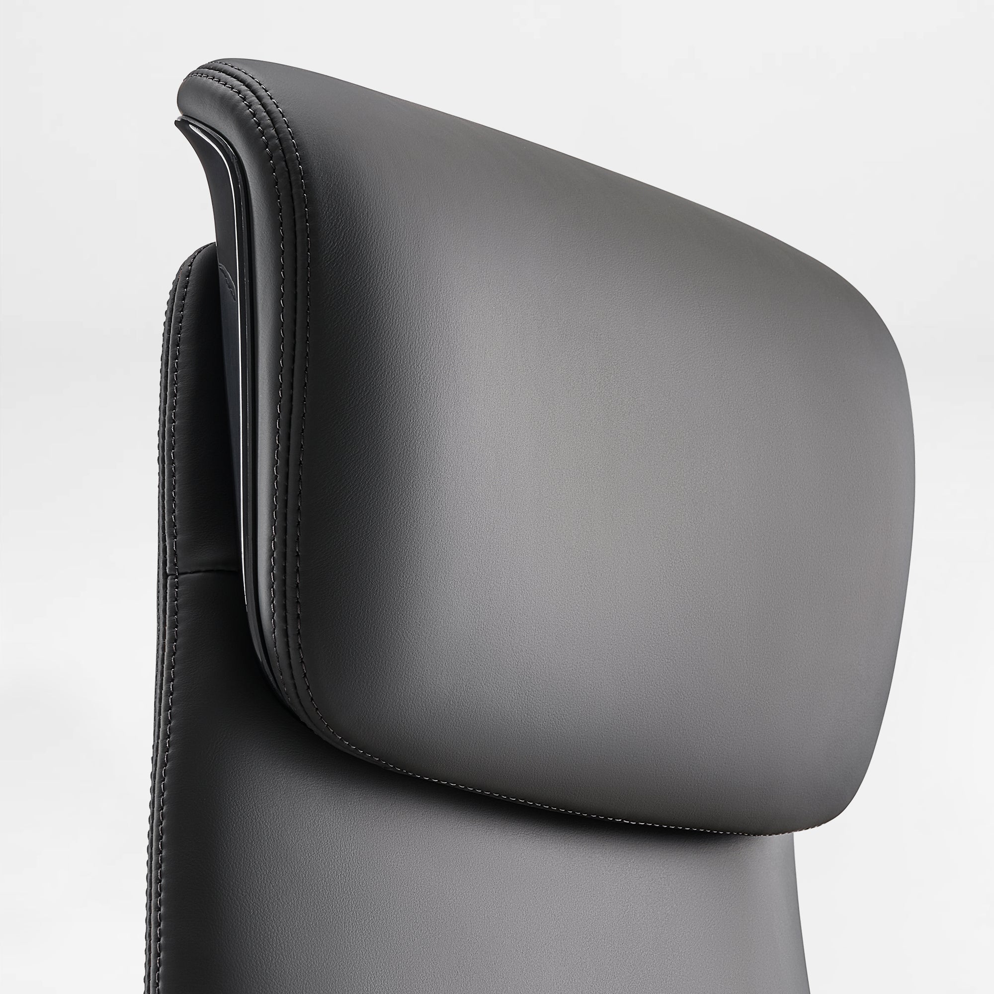 Eureka Ergonomic Serene Aaron black genuine leather executive chair headrest close-up, showing stitching and smooth texture detail.