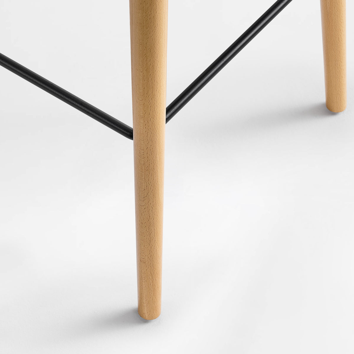 Eureka Ergonomic Perchamp oak leg joined to a black footrest bar