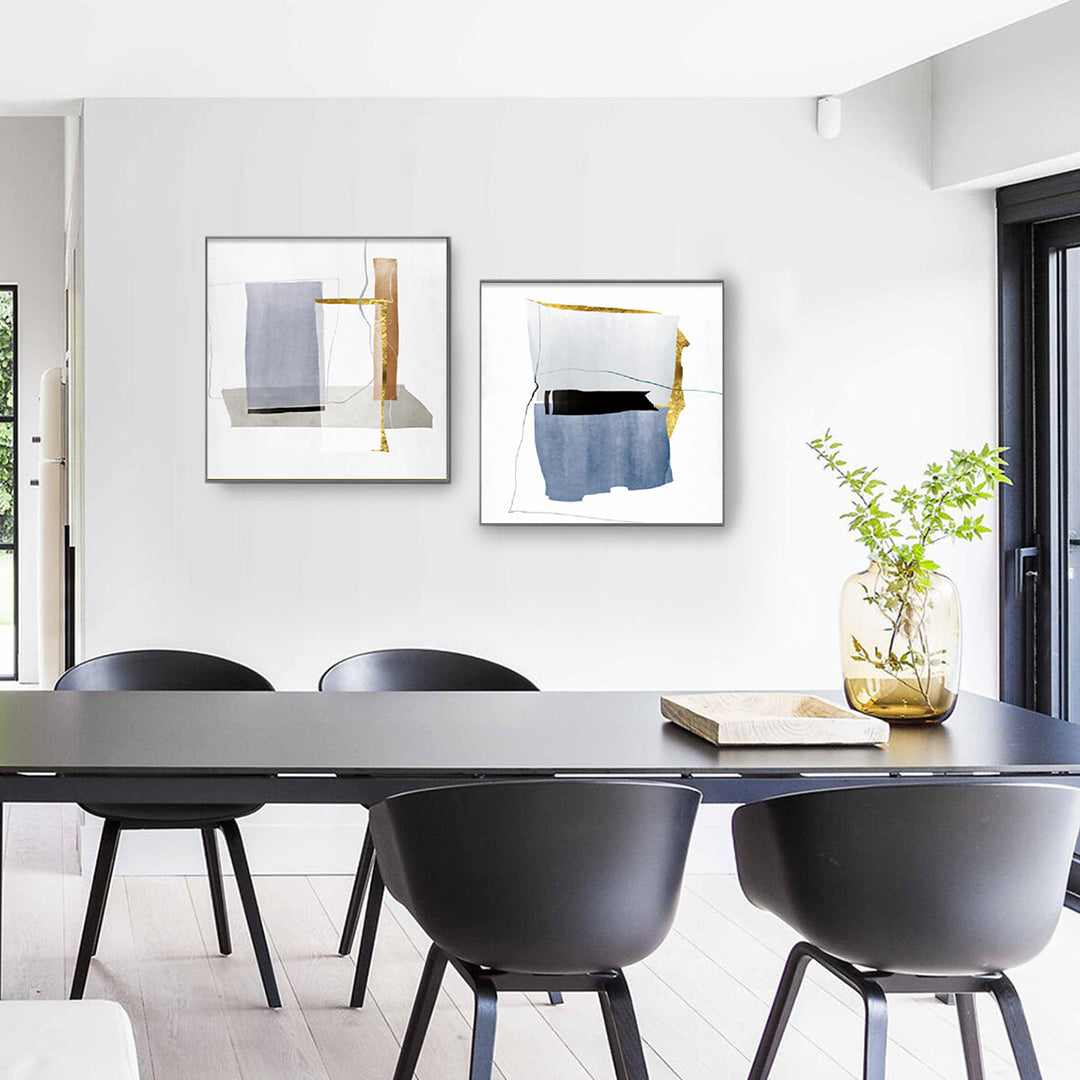 Set of 2 Abstract Wall Art Prints in Blue, Gold, and Gray Geometric Designs Above Dining Table.