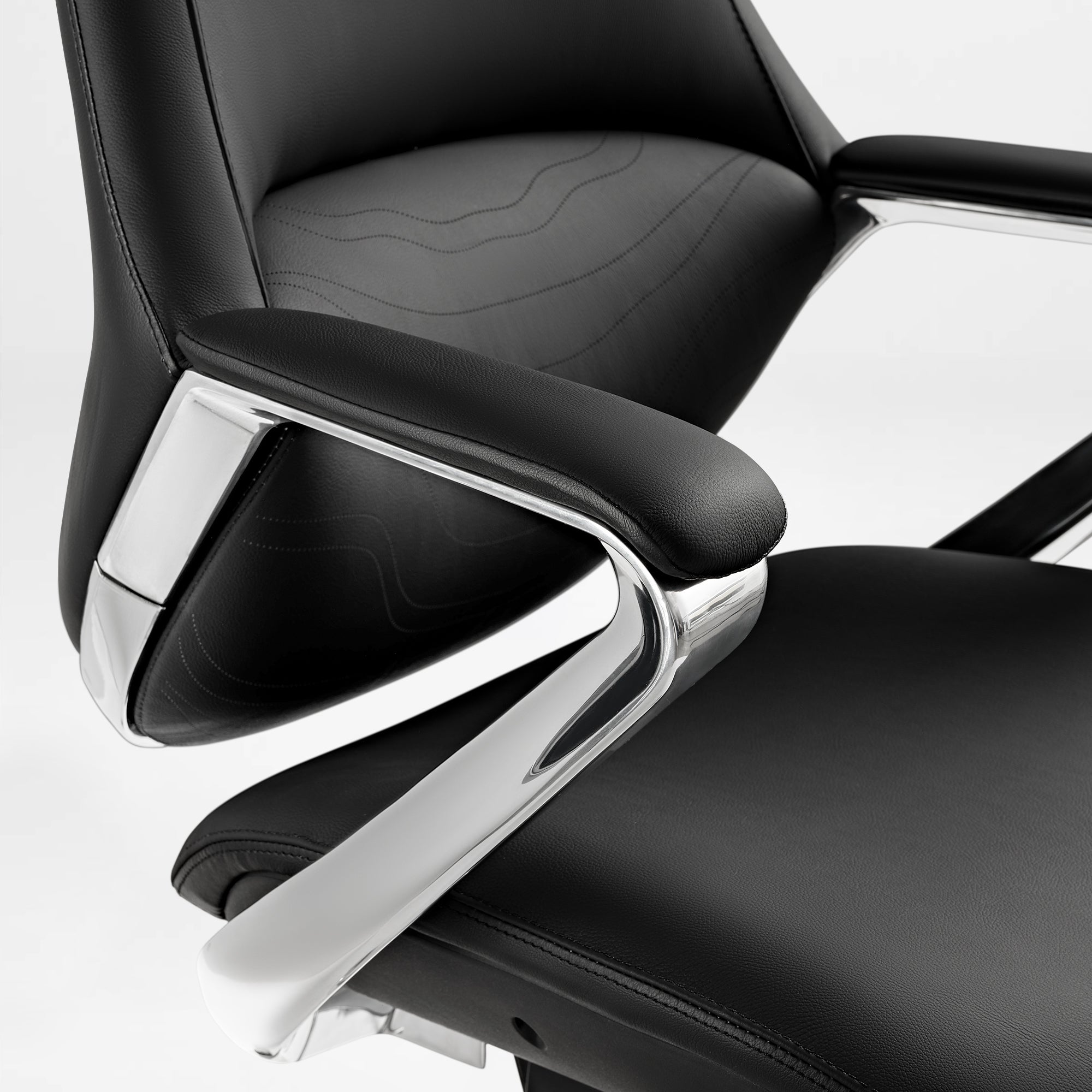 Eureka Ergonomic Nox black leather executive chair close-up: textured material, stitching, chrome accents.
