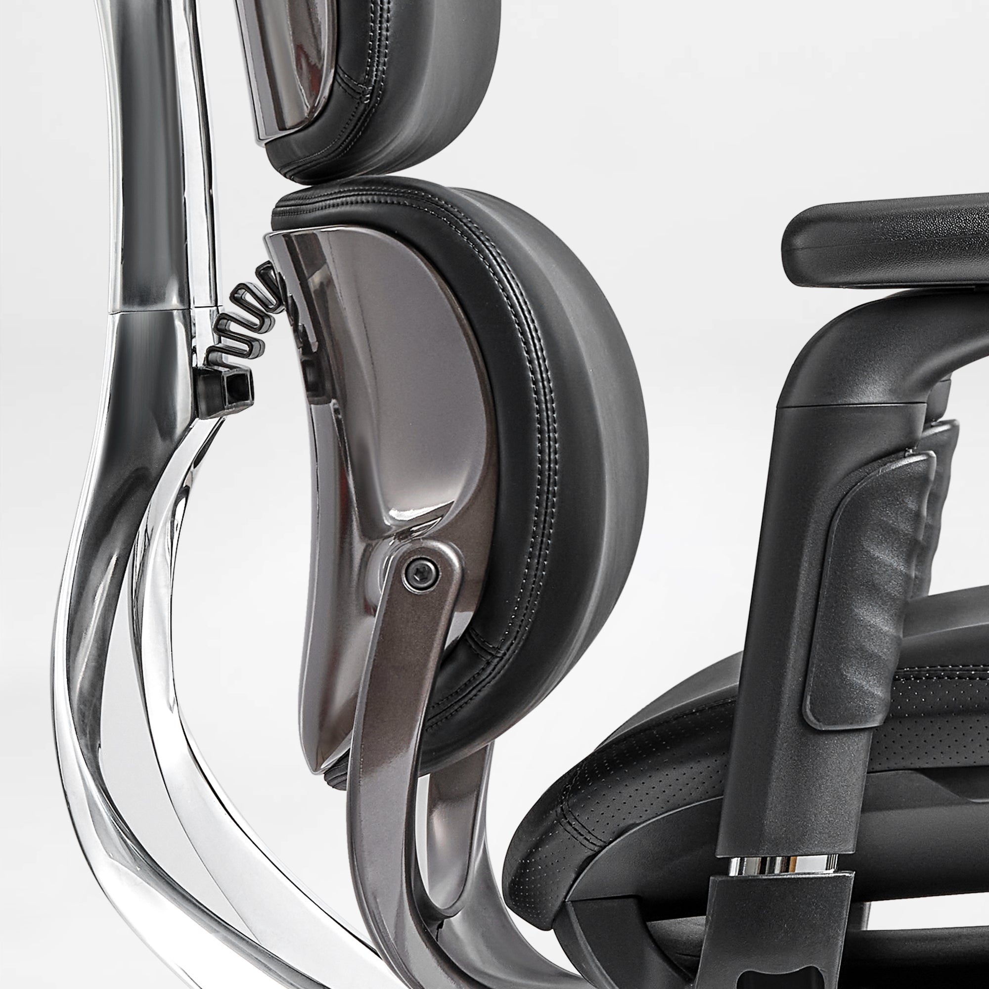 Eureka Ergonomic Black PU leather ergonomic executive chair close-up: stitching, aluminum frame, adjustable headrest mechanism.