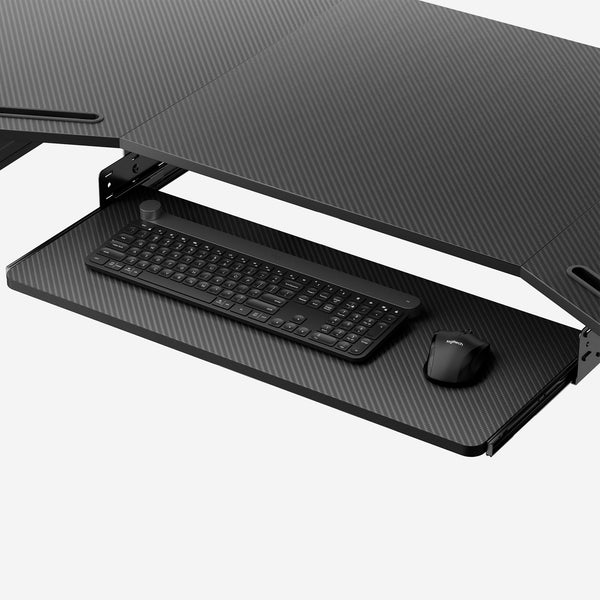 Black Pull-Out Keyboard Tray for Ergonomic Desks, With Carbon Fiber Finish, Featuring a Logitech Keyboard and Mouse.